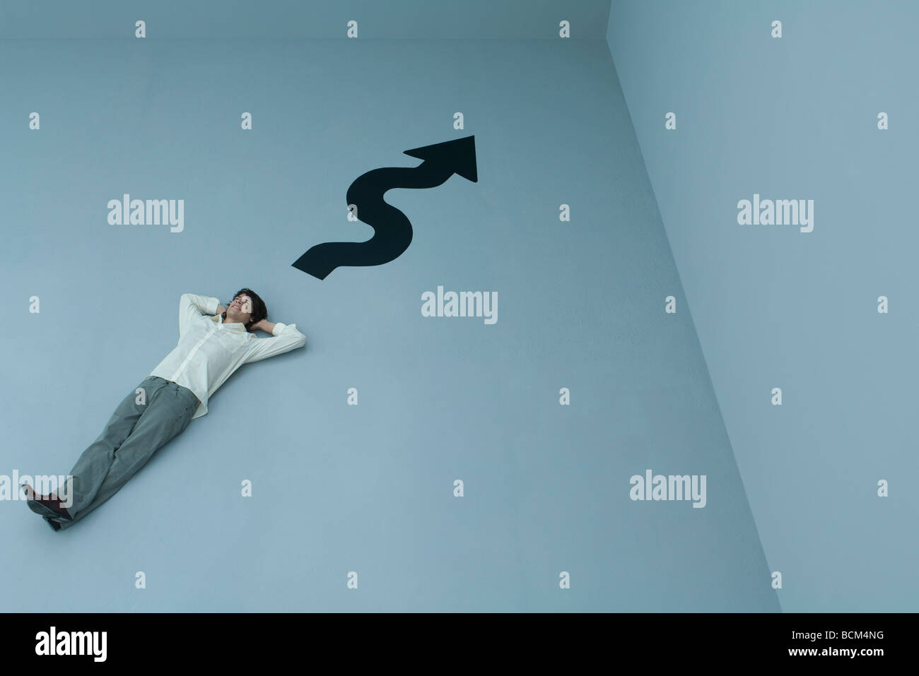 Man lying on the ground with hands behind head, curvy arrow pointing to