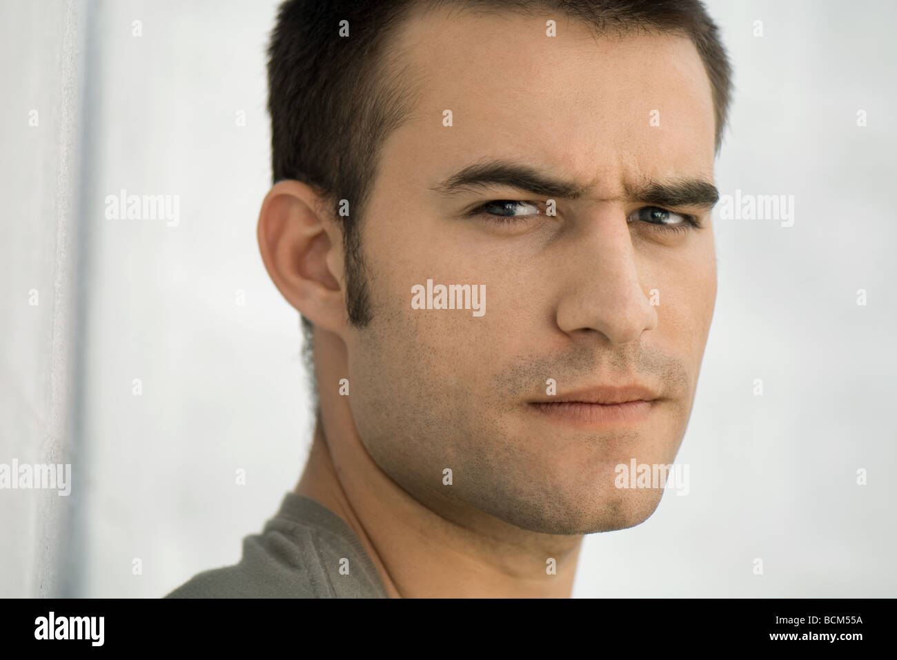 Man frowning at camera, raising one eyebrow Stock Photo