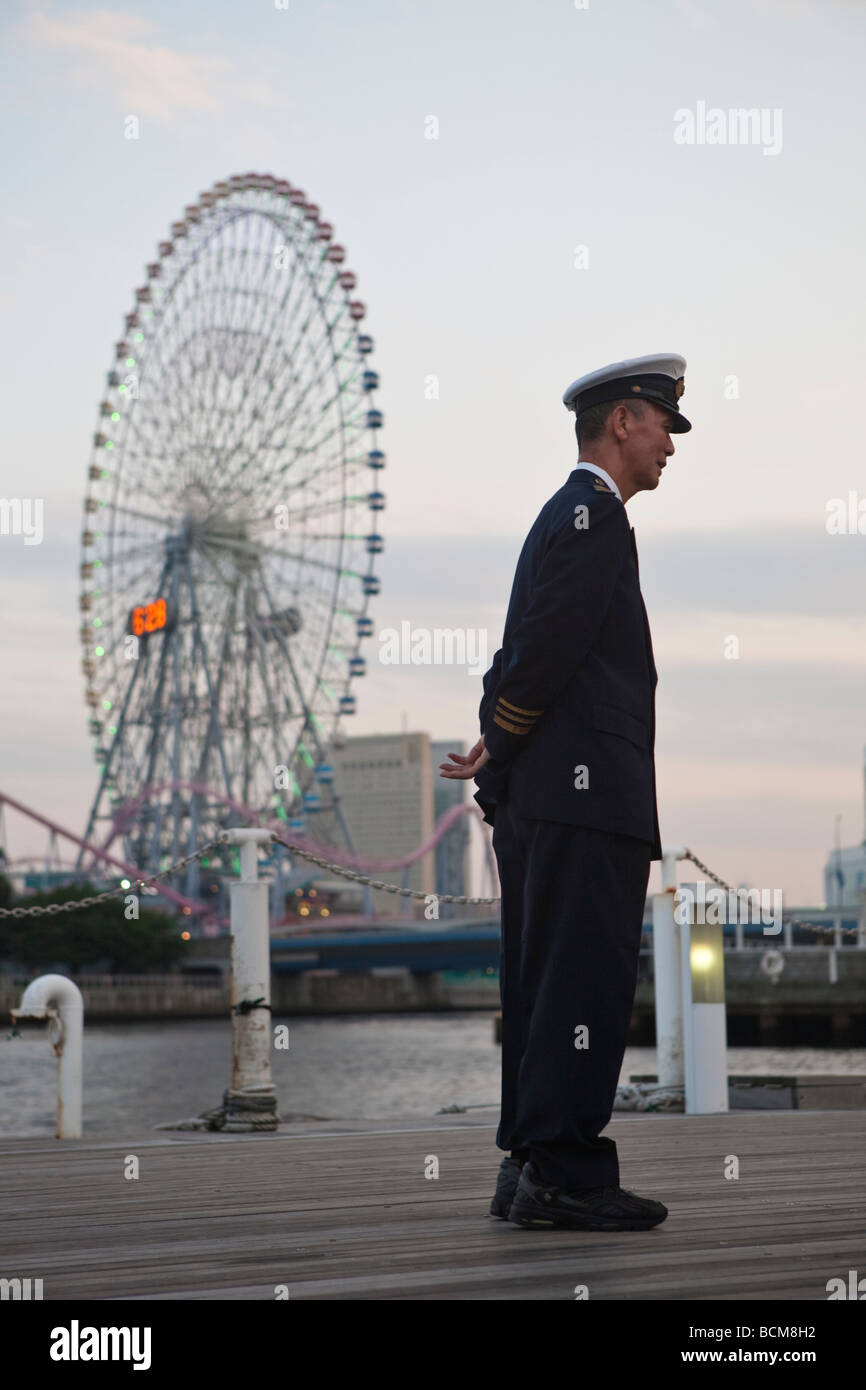Japanese harbor ferry attendant standing in front of carousel in ...