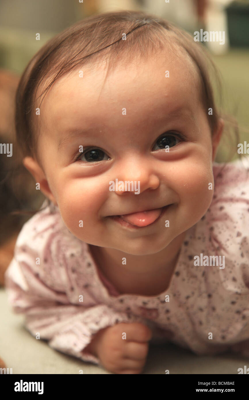 6 month old baby girl poking out tongue Stock Photo