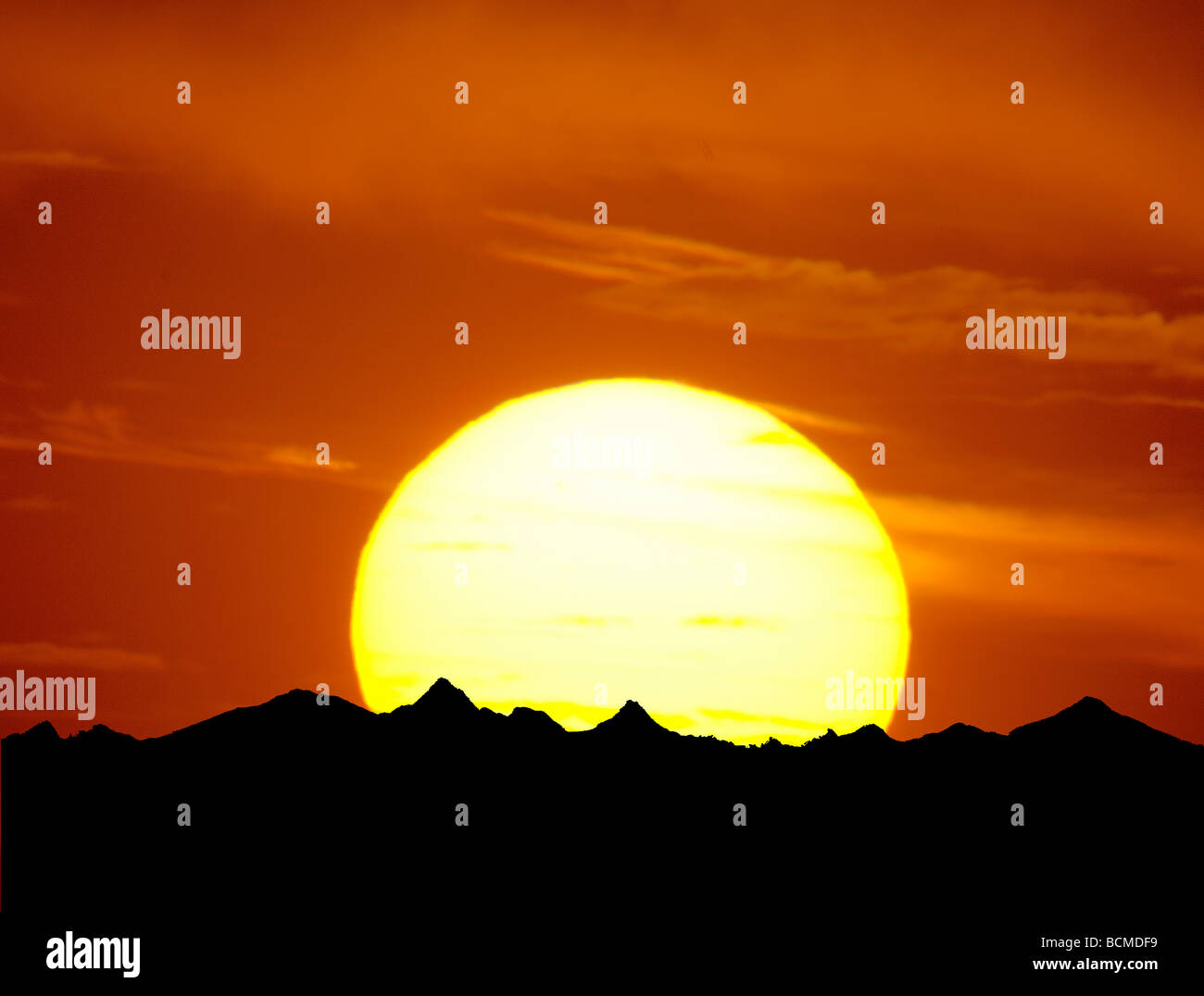 telephoto photograph of large sunset and mountains Stock Photo