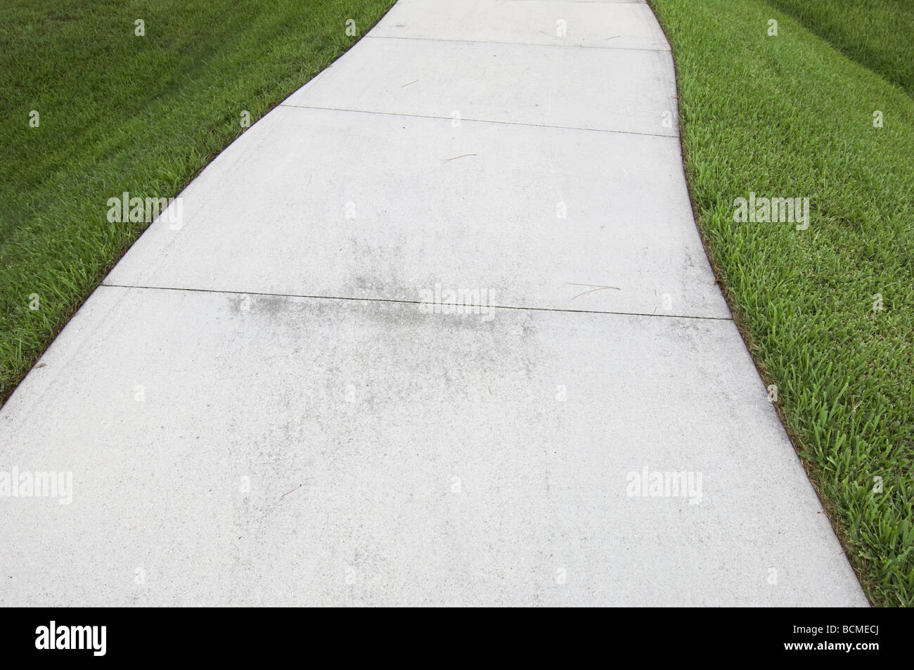 curved sidewalk through grass Stock Photo
