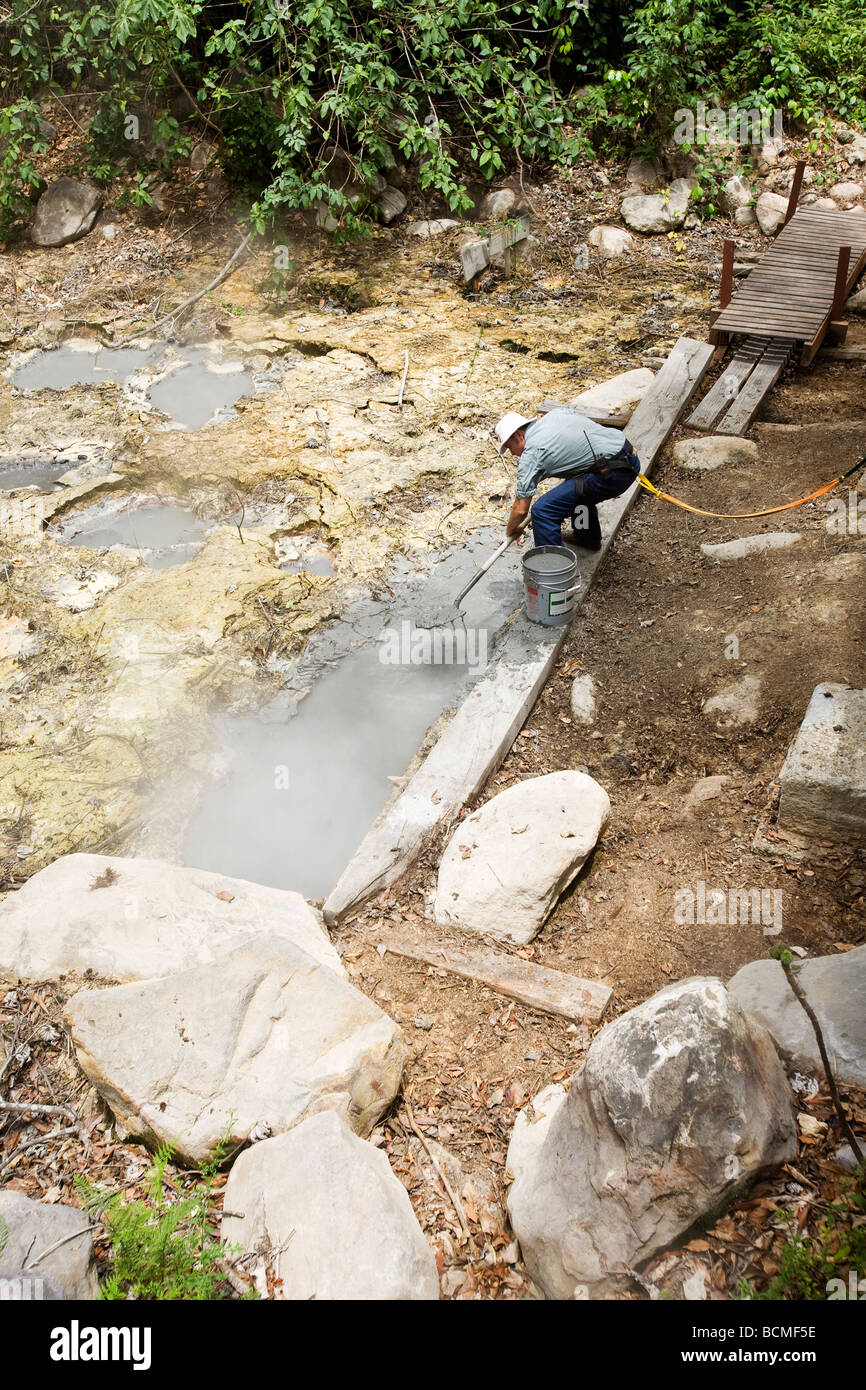A worker collects boiling mud from the hot springs on the slopes of Rincon de Viejo. The mud will be used for skin treatments. Stock Photo