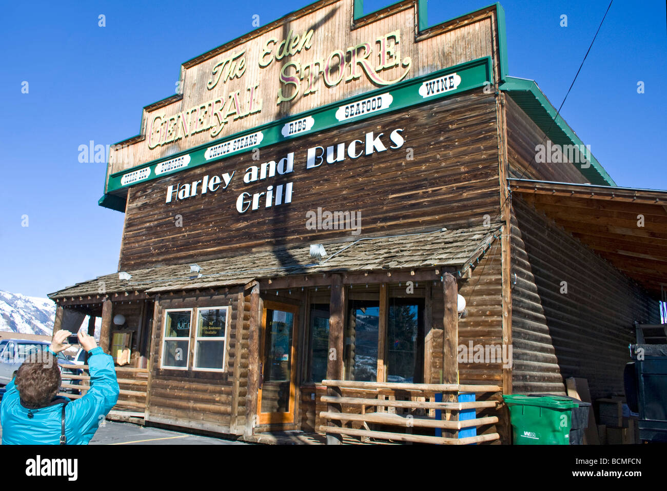 Woman photographs Harley and Bucks Grill in Eden, Utah, a former general store that now