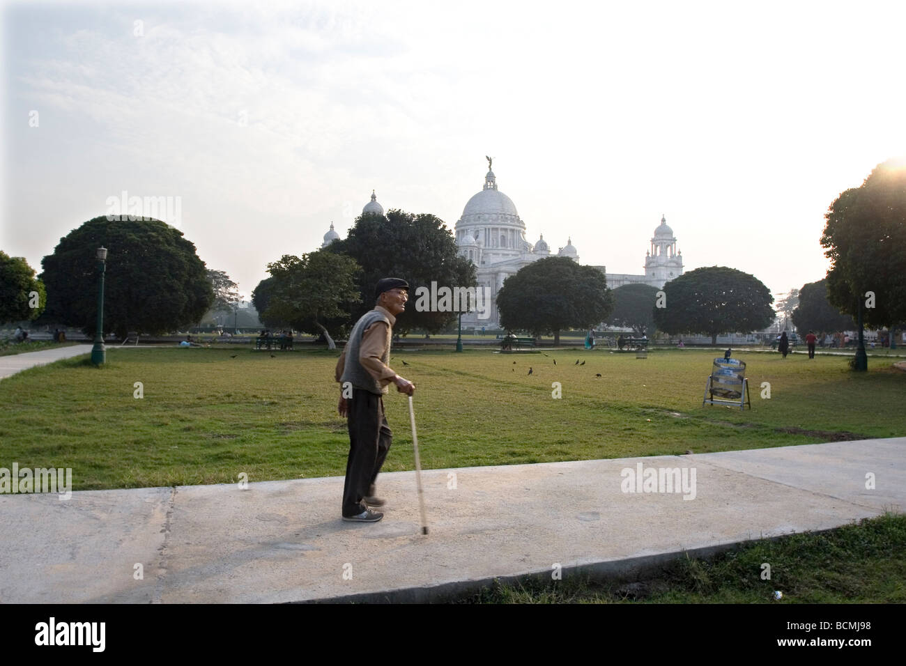 An aged man enjoys walking in front of the famous Victoria Memorial Hall,a favourite landmark of Kolkata,West Bengal,India Stock Photo