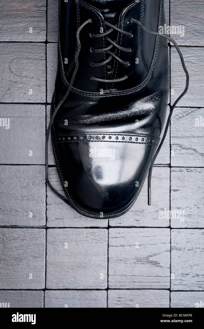 A black leather business shoe with laces untied Stock Photo