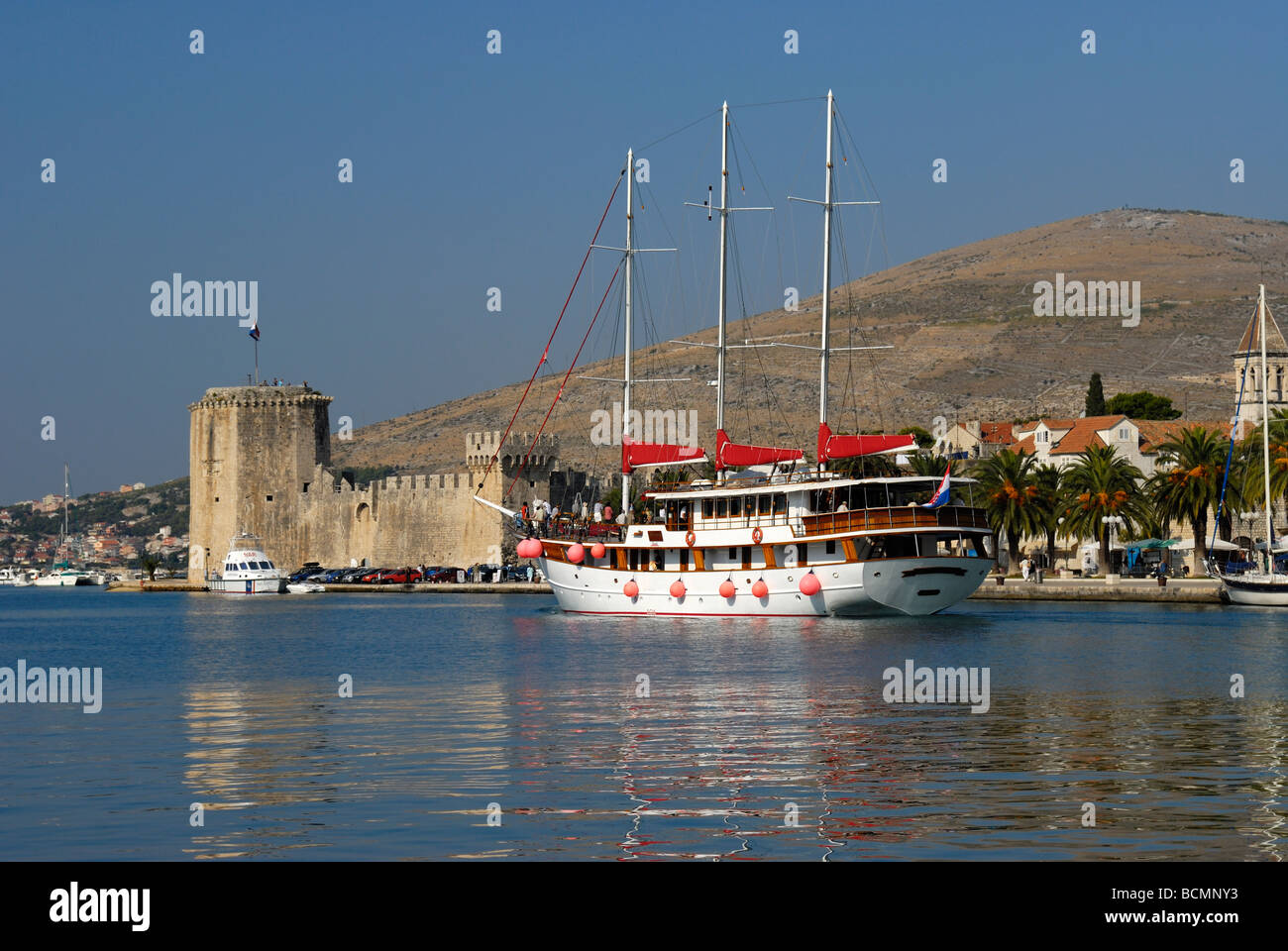 Three masted yacht with Kamerlengo Castle in background at Trogir on Dalmatian Coast of Croatia Stock Photo