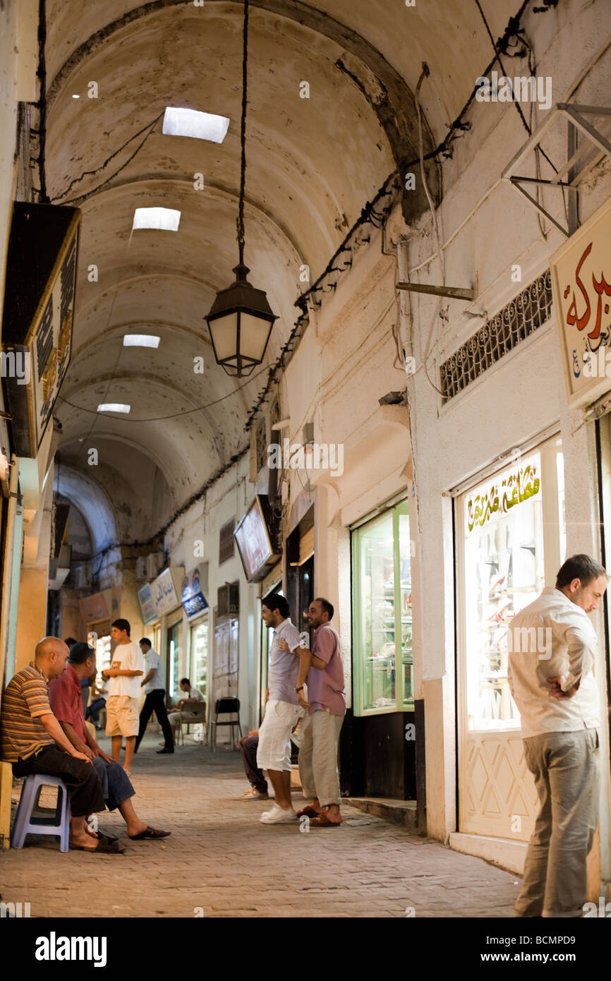Shoppers stroll the tunnels of the Medina (old city) in Tunis, Tunisia.  The Tunis Medina is a UNESCO World Heritage Site. Stock Photo