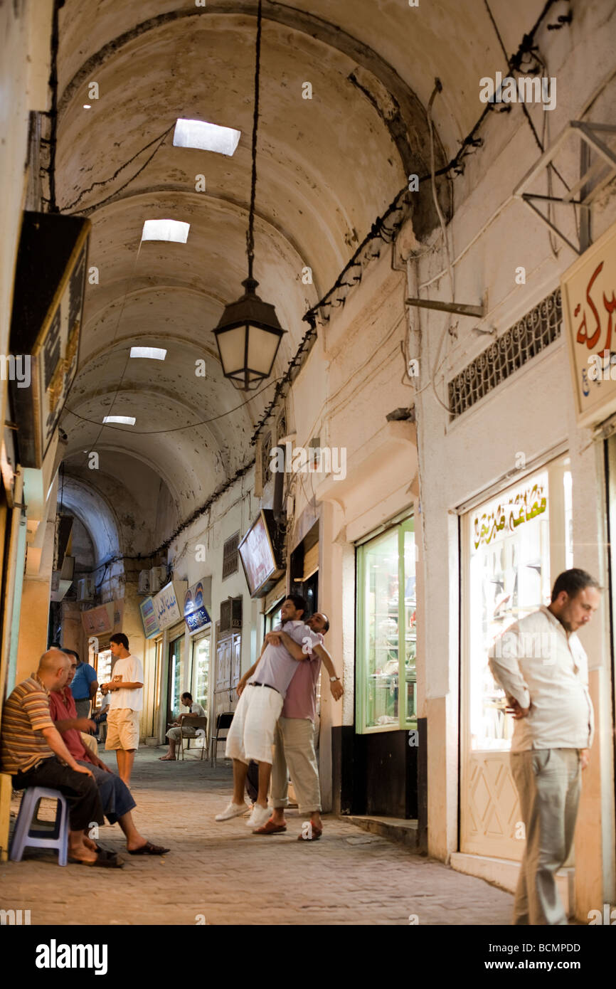 Shoppers stroll the tunnels of the Medina (old city) in Tunis, Tunisia.  The Tunis Medina is a UNESCO World Heritage Site. Stock Photo