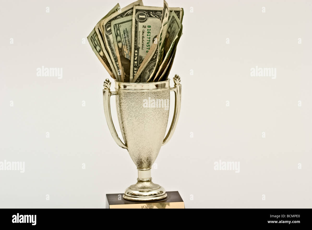 Cash inside a trophy cup Stock Photo
