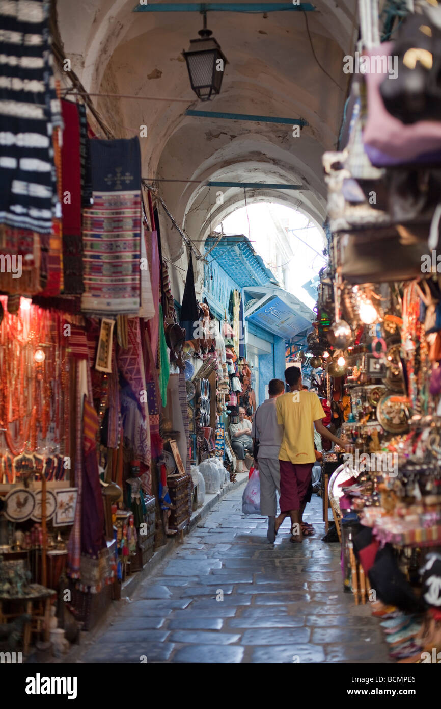 Shoppers stroll the tunnels of the Medina (old city) in Tunis, Tunisia.  The Tunis Medina is a UNESCO World Heritage Site. Stock Photo