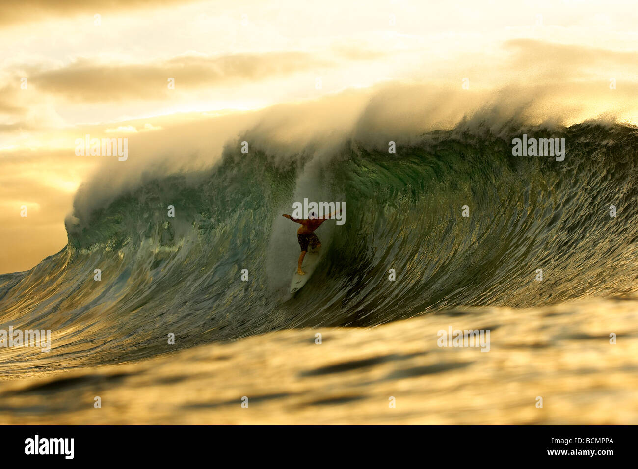 Riding a wave at sunset Stock Photo Alamy