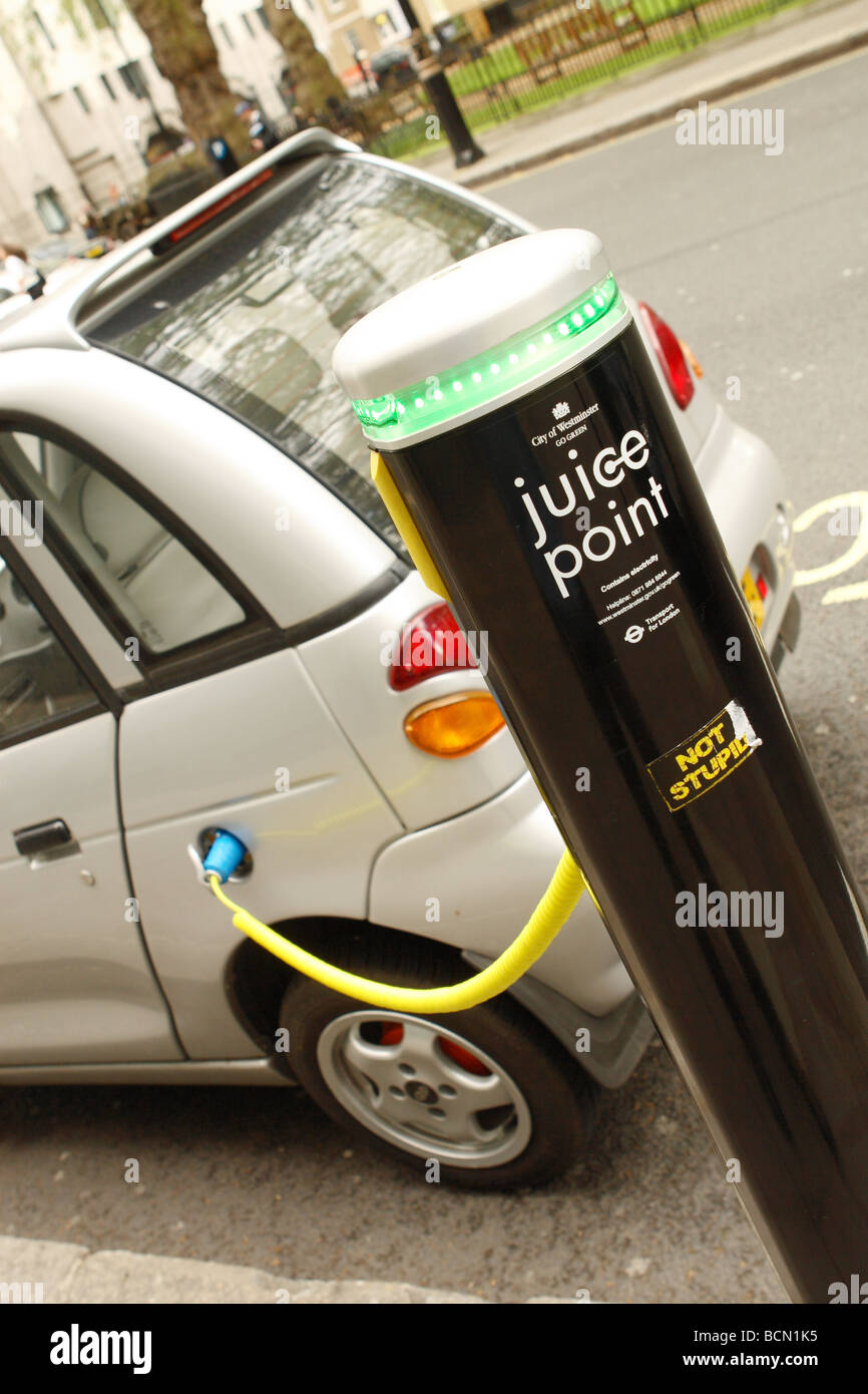 London electric car Juice Point electricity power recharging post in Westminster with G Wiz electric car vehicle connected Stock Photo