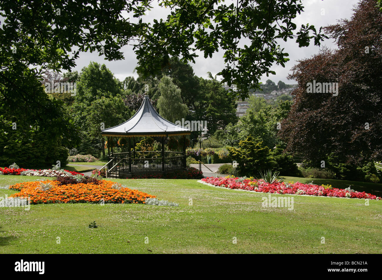 City of Truro, England. Flower beds in full bloom in Truro’s Victoria Gardens, with the Victorian bandstand in the background. Stock Photo