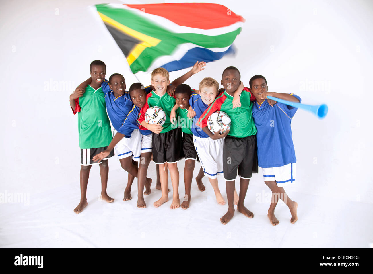 A group of young mixed race boys in soccer supporters kit with South