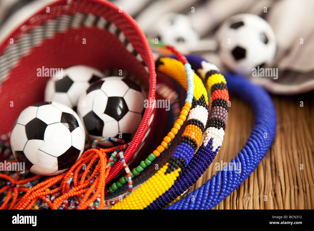 A close-up of African beadwork and miniature soccer balls in a beaded woven African basket Stock Photo