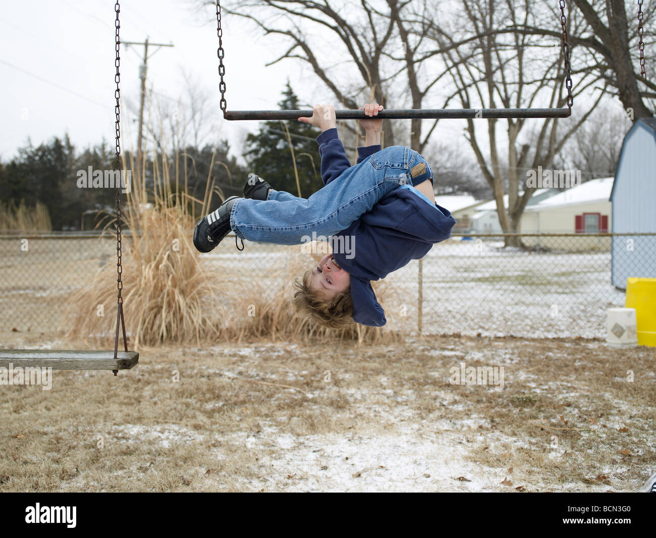 Boy Hanging Upside Down From Bar Stock Photo Alamy