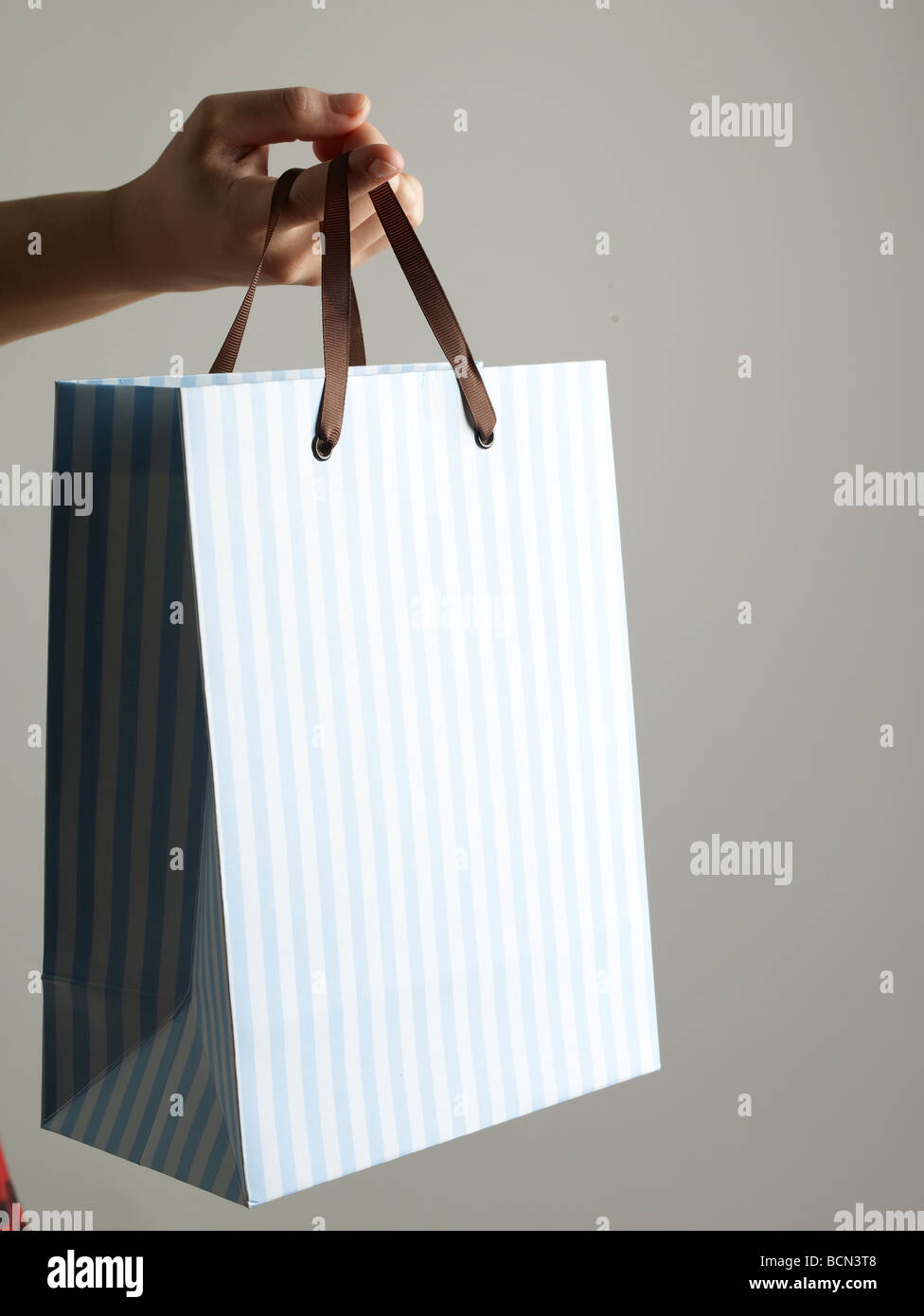 Shopping Bag Hanging From Finger Stock Photo