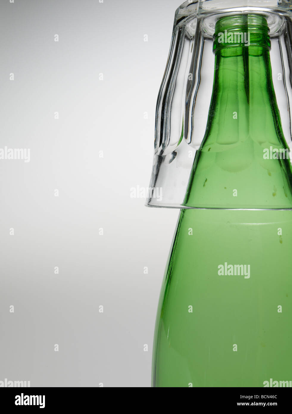 Close-Up of Glass Over Green Bottle Stock Photo