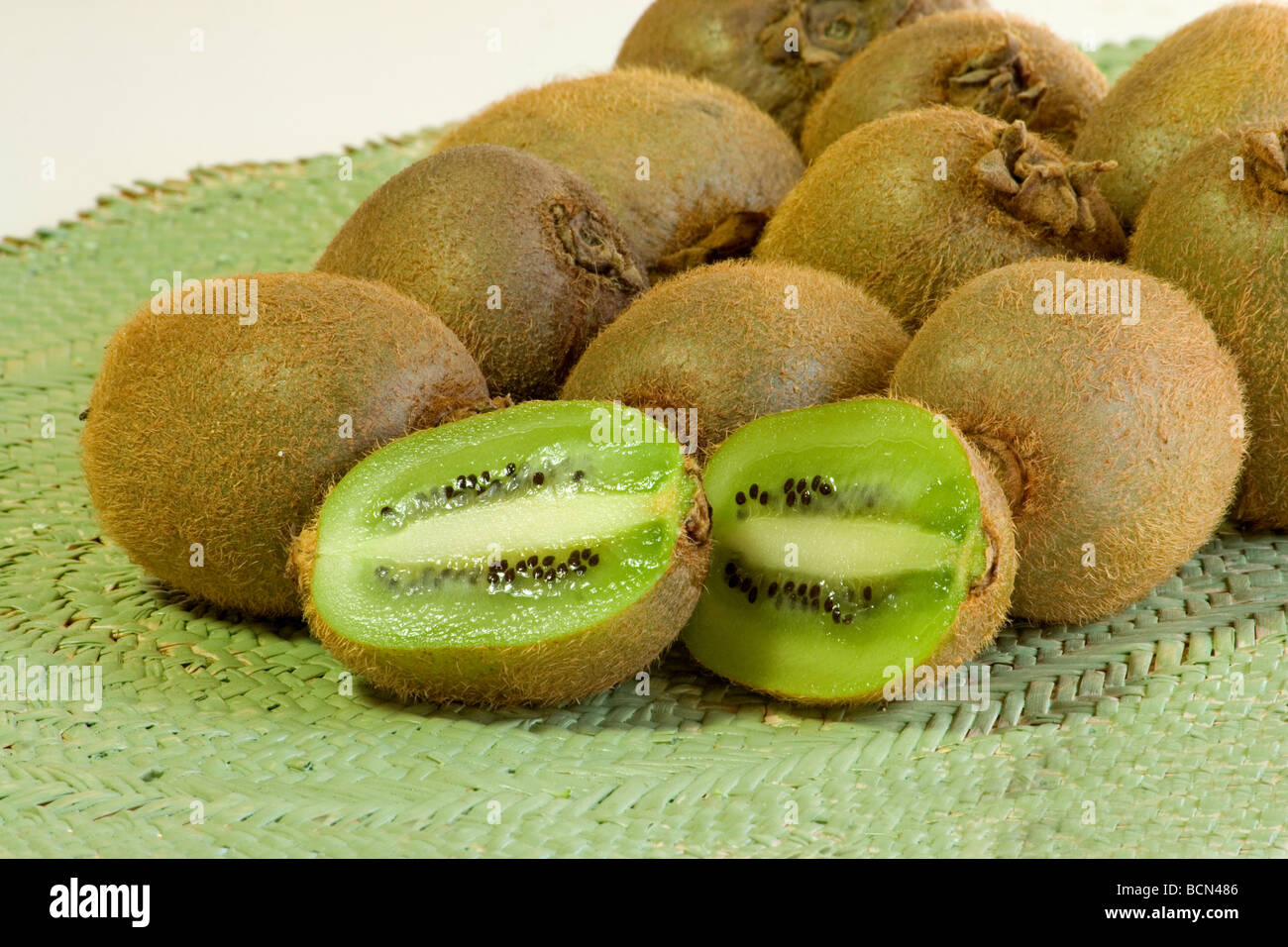 Close-up of kiwi fruits on wicker mat isolated on white Stock Photo