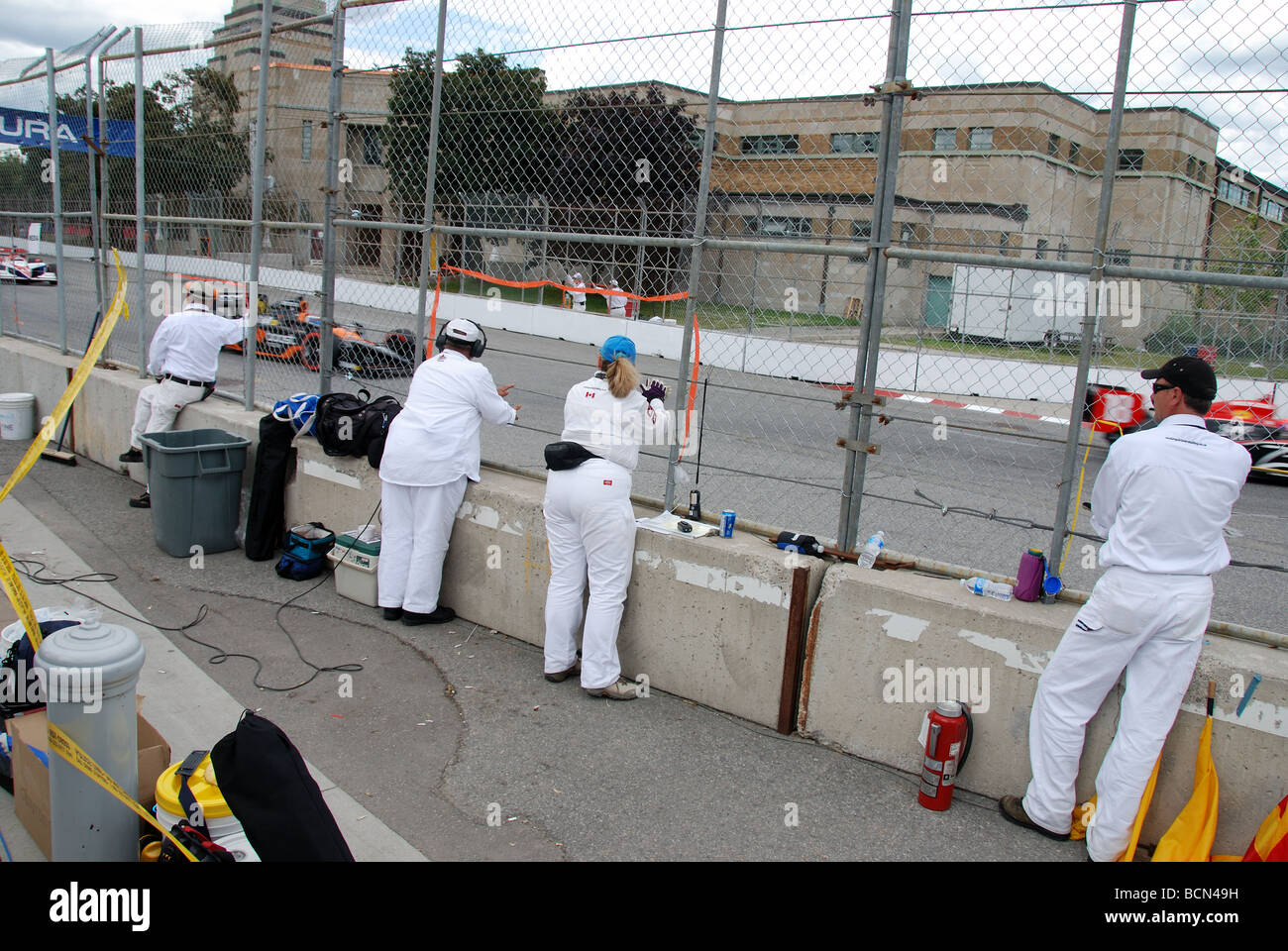 Safety officials watch cars at the Honda Indy race in Toronto Ontario Canada Stock Photo