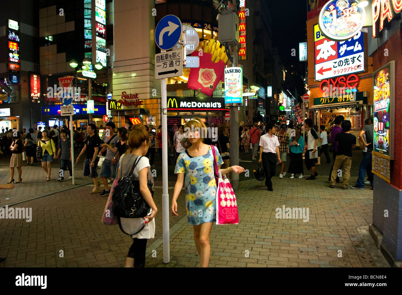 Pedestrians at a bustling shopping street in Shibuya district Tokyo Japan Stock Photo