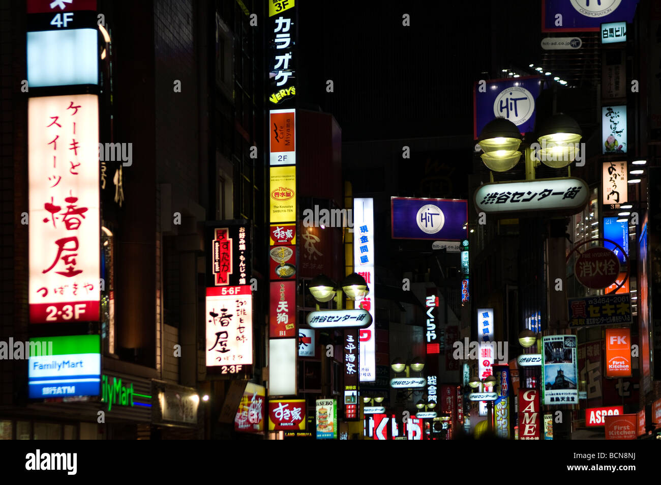 Neon lights and advertisement signs cover building facades in Shibuya district Tokyo Japan Stock Photo