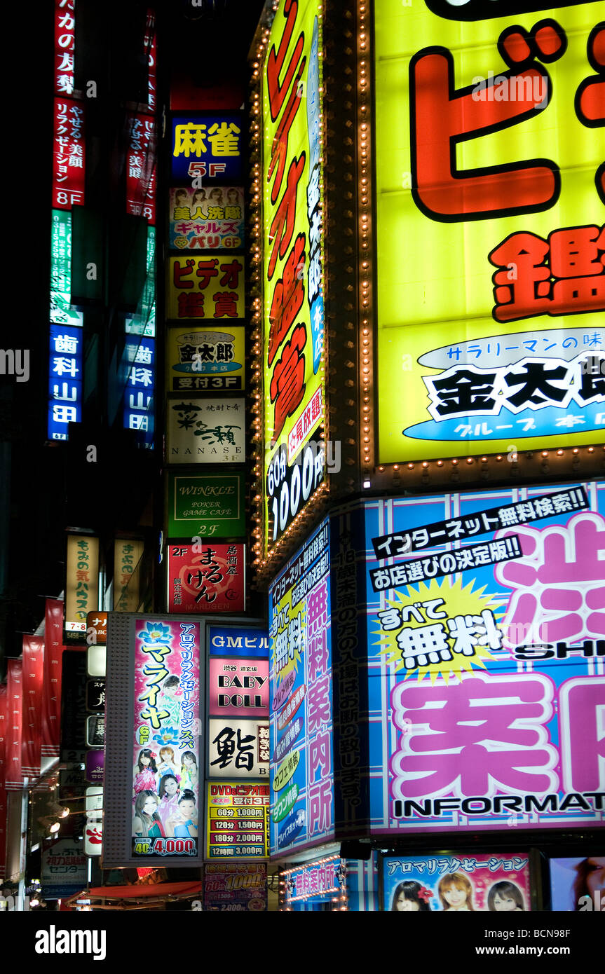 Neon lights and advertisement signs cover building facades in Shibuya district Tokyo Japan Stock Photo