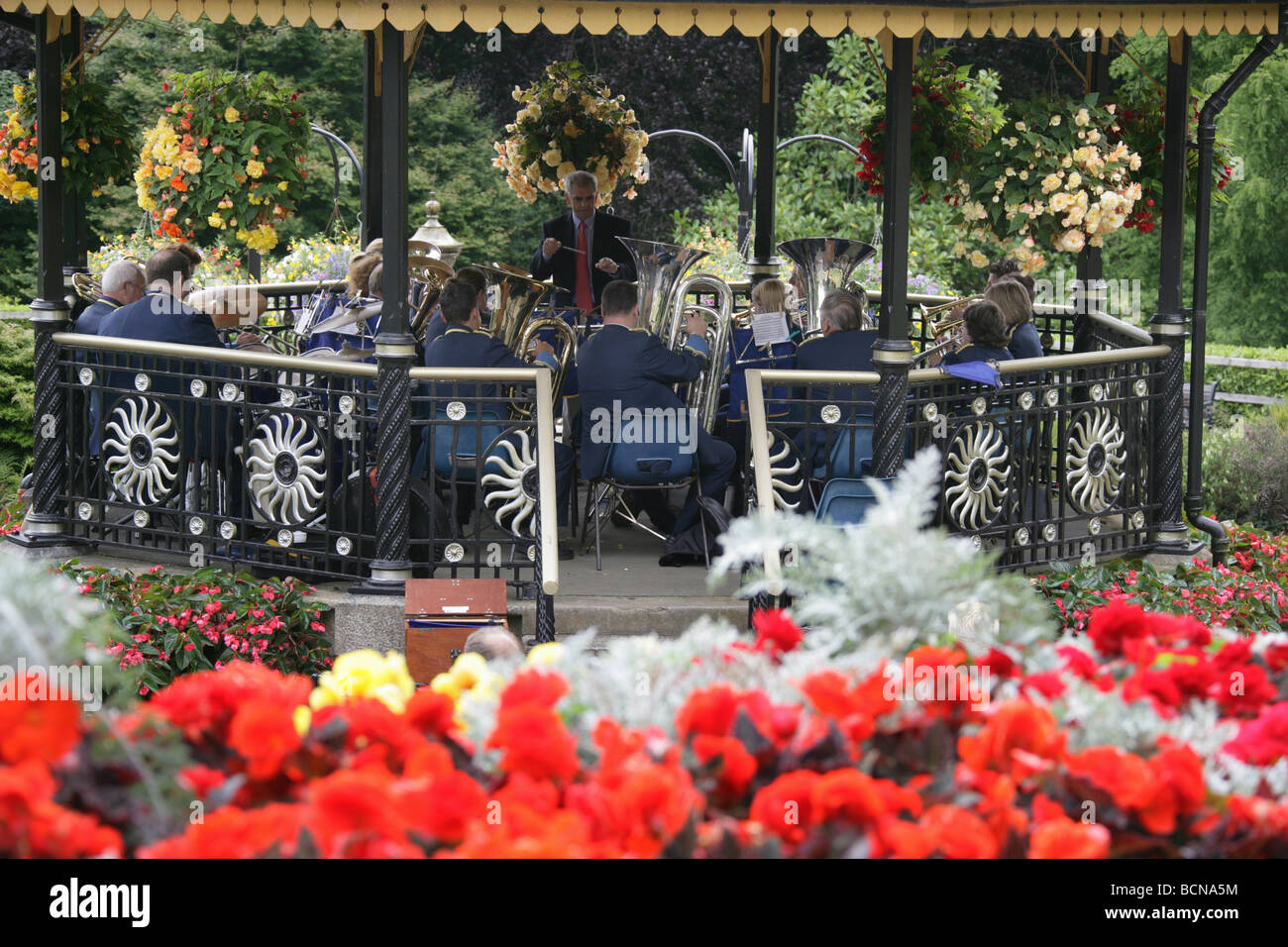 City of Truro, England. Flower beds in full bloom in Victoria Gardens, with a brass band playing in the Victorian bandstand. Stock Photo