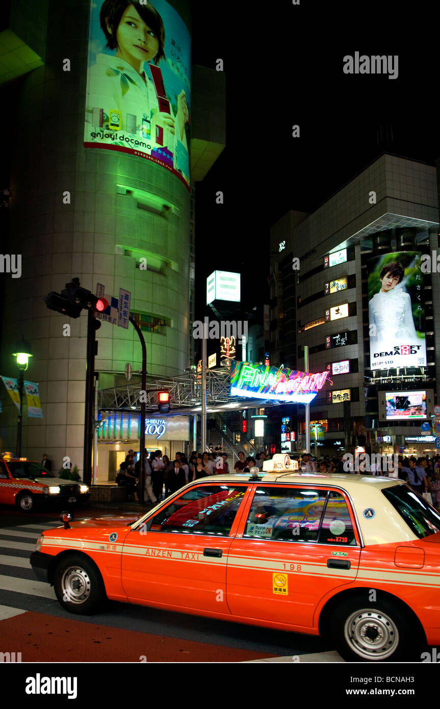 A bustling nighttime street scene in Shibuya commercial district Tokyo Japan Stock Photo