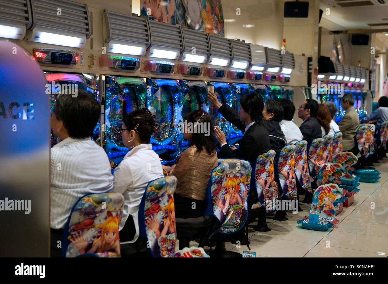 People playing the popular Pachinko pinball gambling machines in Jumbo Pachinko parlor in Shibuya district Tokyo Japan Stock Photo