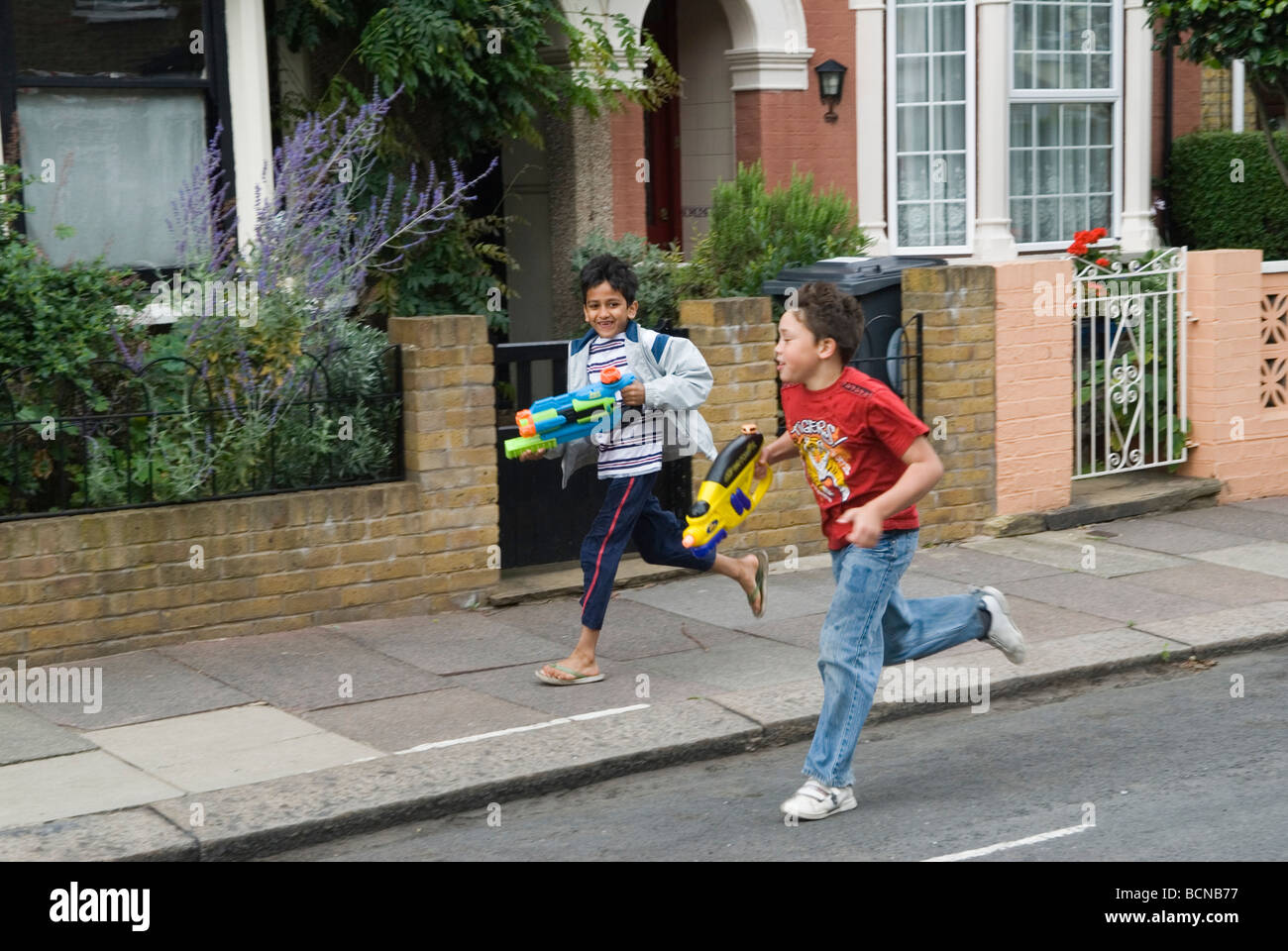 Children playing in Brunswick Street Walthamstow London E17 England with pump action water pistols 2009 2000s UK. HOMER SYKES Stock Photo