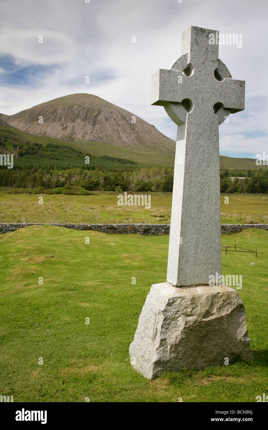 Celtic cross grave memorial in Cill Chriosd churchyard with Beinn na Caillich (732m / 2401ft) behind. Isle of Skye, Scotland. Stock Photo