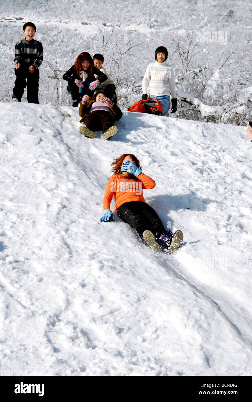 Young women sliding down the slope, Xiling Ski Resort, Xiling Snow