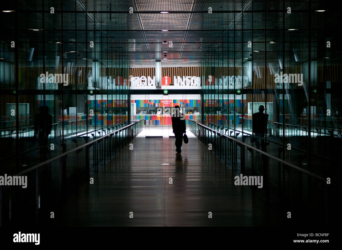 A pedestrian pass a glassed corridor at the Tokyo international forum cultural center in Marunouchi district Tokyo Japan Stock Photo