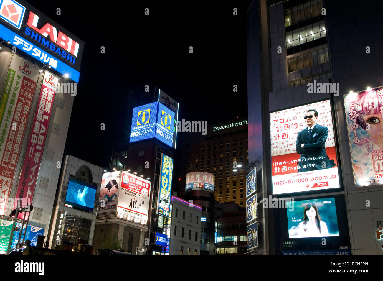 Neon lights and advertisement signs cover building facades in Shimbashi district Tokyo Japan Stock Photo