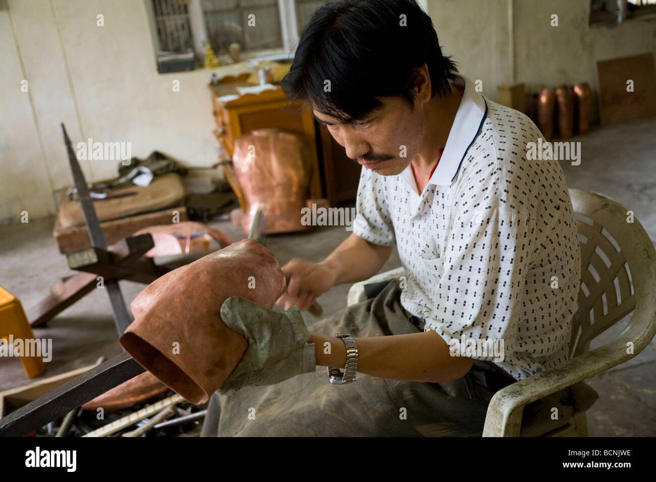 Tibetan refugee working in the metal workshop at the Norbulingka Institute. Sidhpur, Dharamsala. Himachal Pradesh. India. Stock Photo