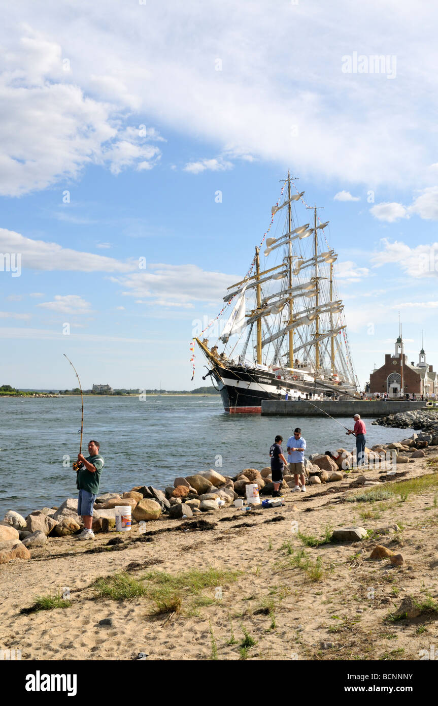 People fishing along Cape Cod Canal with Tall Ship Kruzenshtern docked