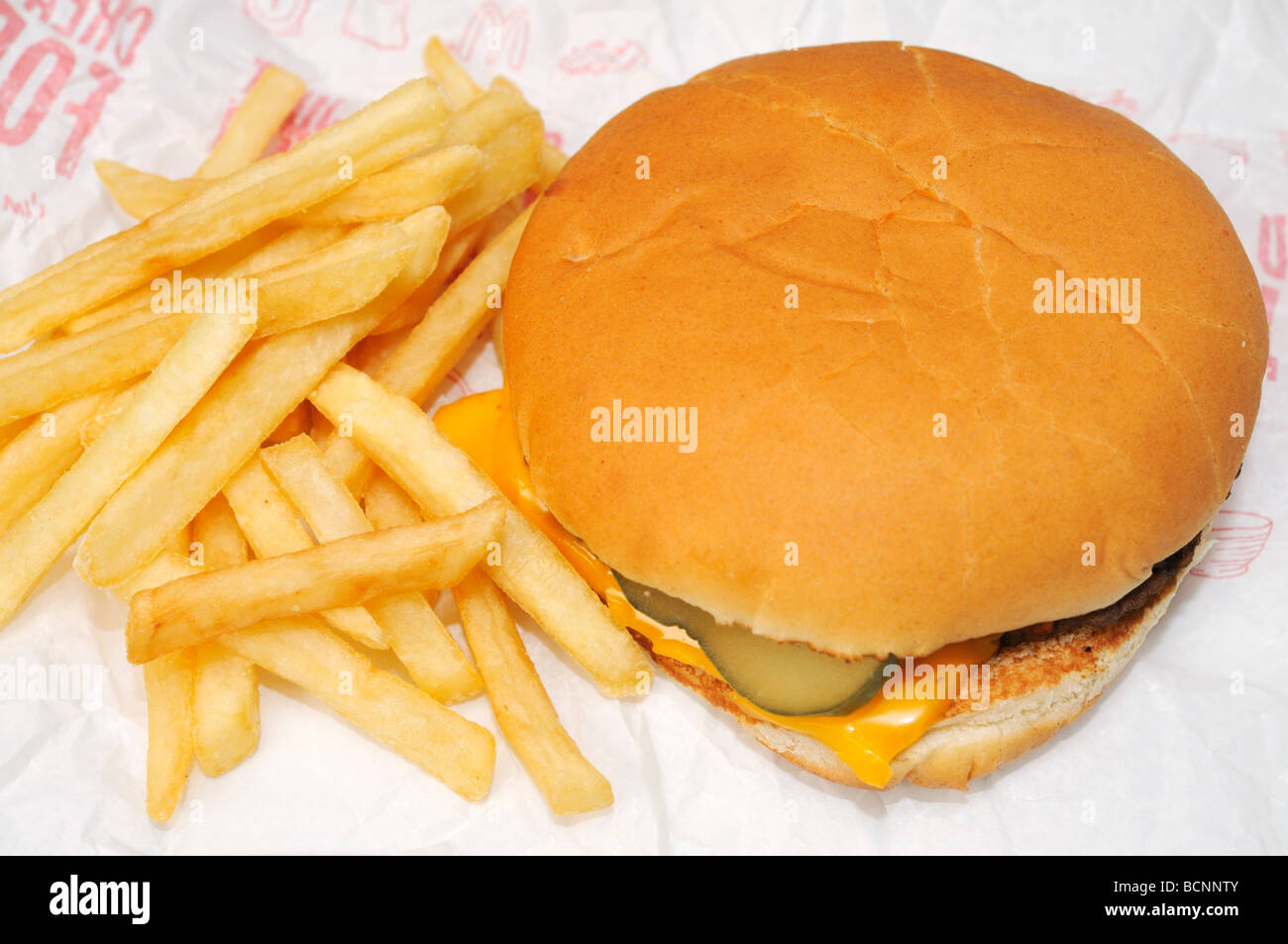 Mcdonalds cheeseburger and french fries on open wrapper Stock Photo