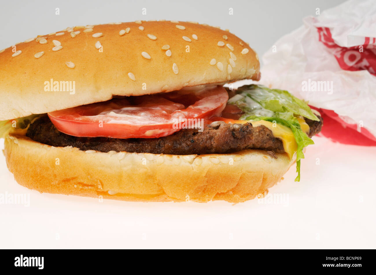Close up of Burger King Whopper sandwich with discarded wrapper on white background Stock Photo