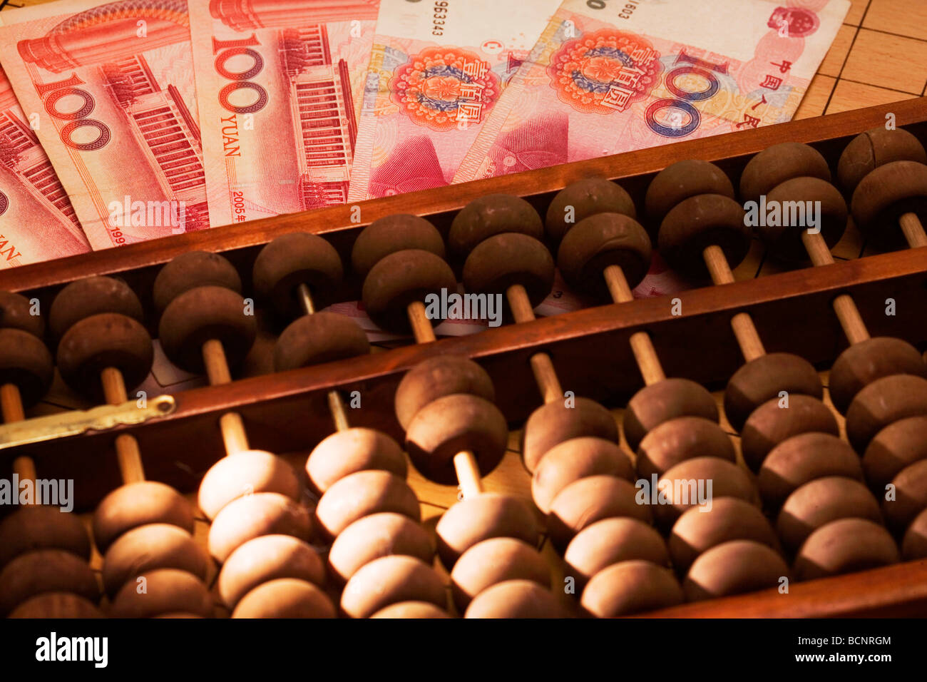 Chinese traditional calculator abacus with one hundred Chinese RMB bills Stock Photo