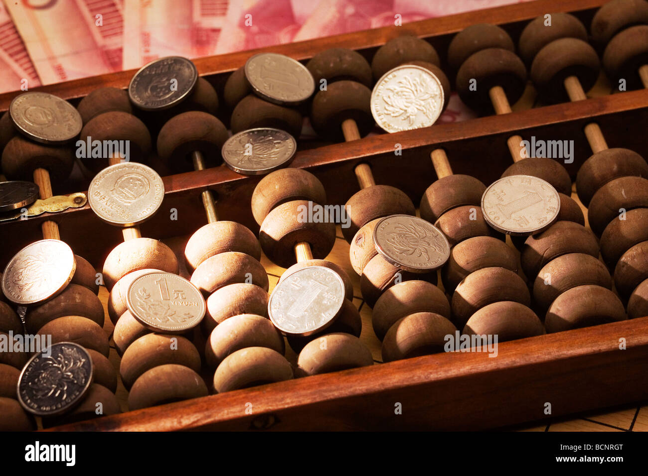 Chinese traditional calculator abacus with one hundred Chinese RMB bills and one Yuan coins Stock Photo