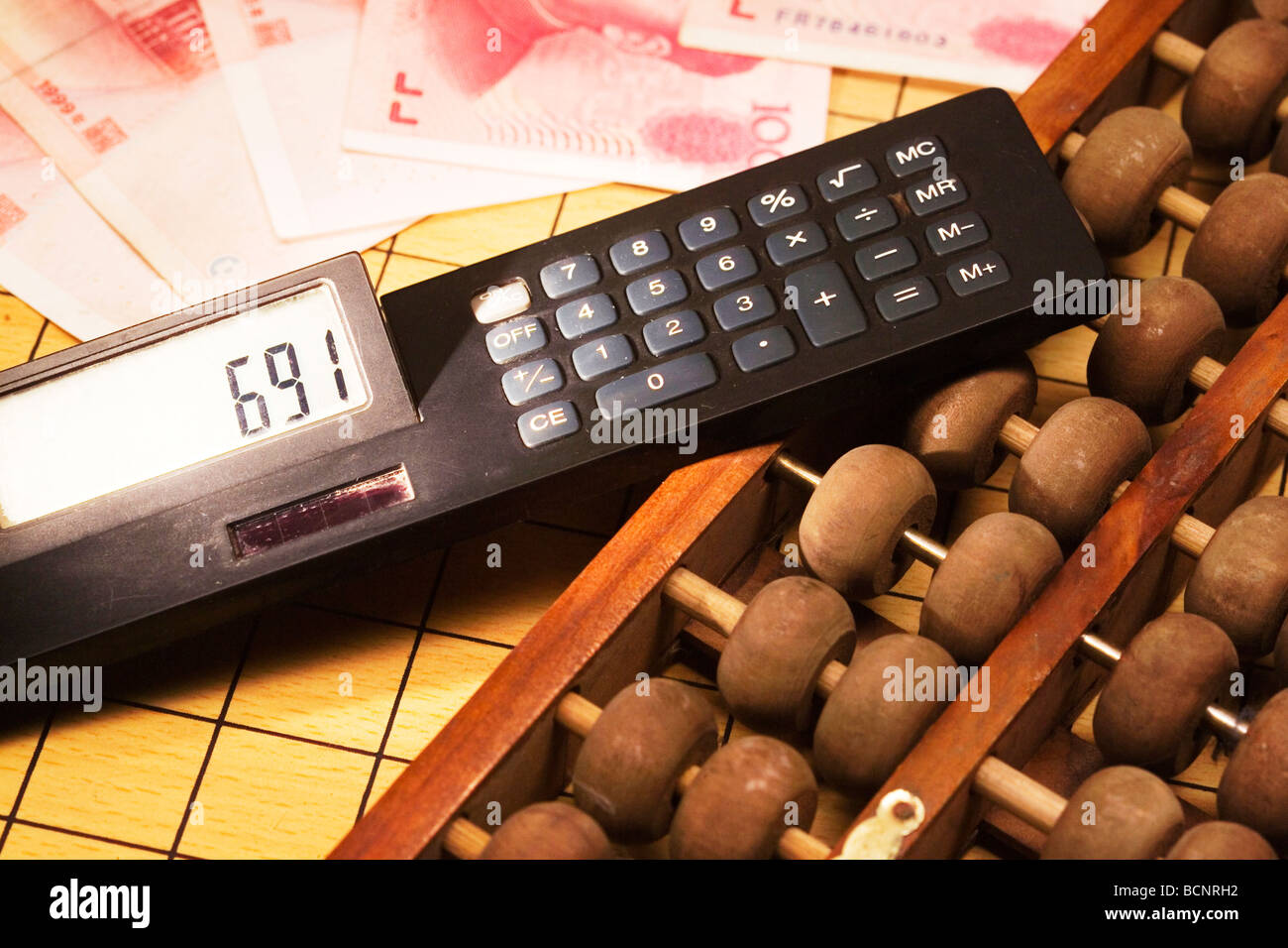Chinese traditional calculator abacus and modern calculator with one hundred Chinese RMB bills Stock Photo