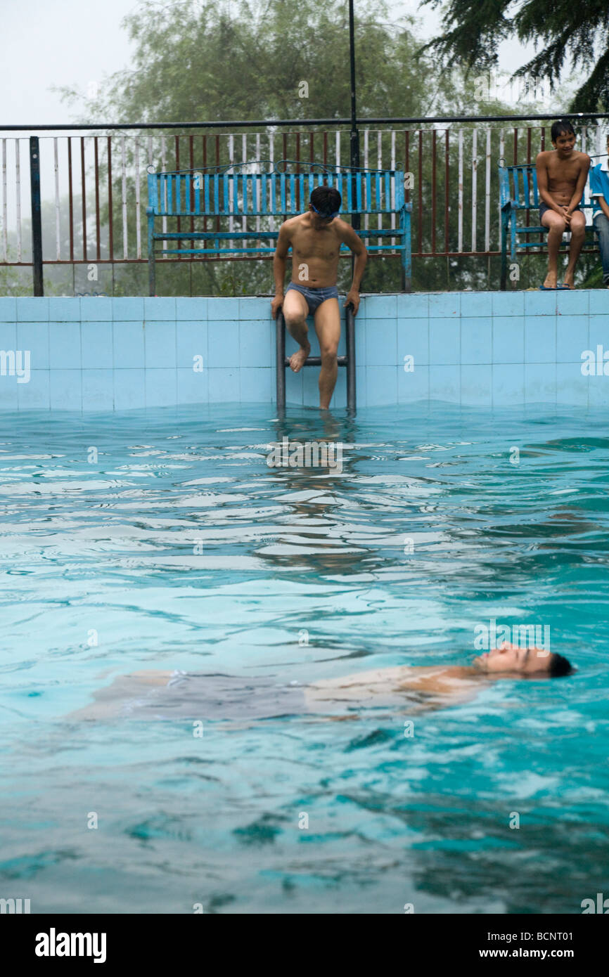 Indian swimmers enjoy the outdoor swimming pool at Bhagsu, near McLeod Ganj. Dharamsala. India. Stock Photo