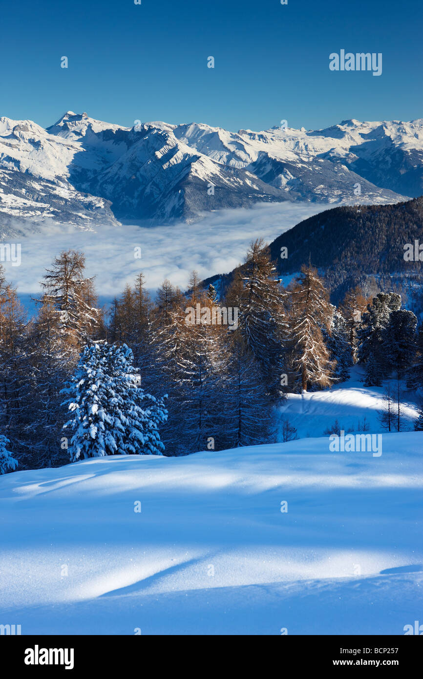 a fresh snowfalll on the slopes above the alpine village of La Tzoumas,with the Rhone Valley beyond, Valais Region, Switzerland Stock Photo