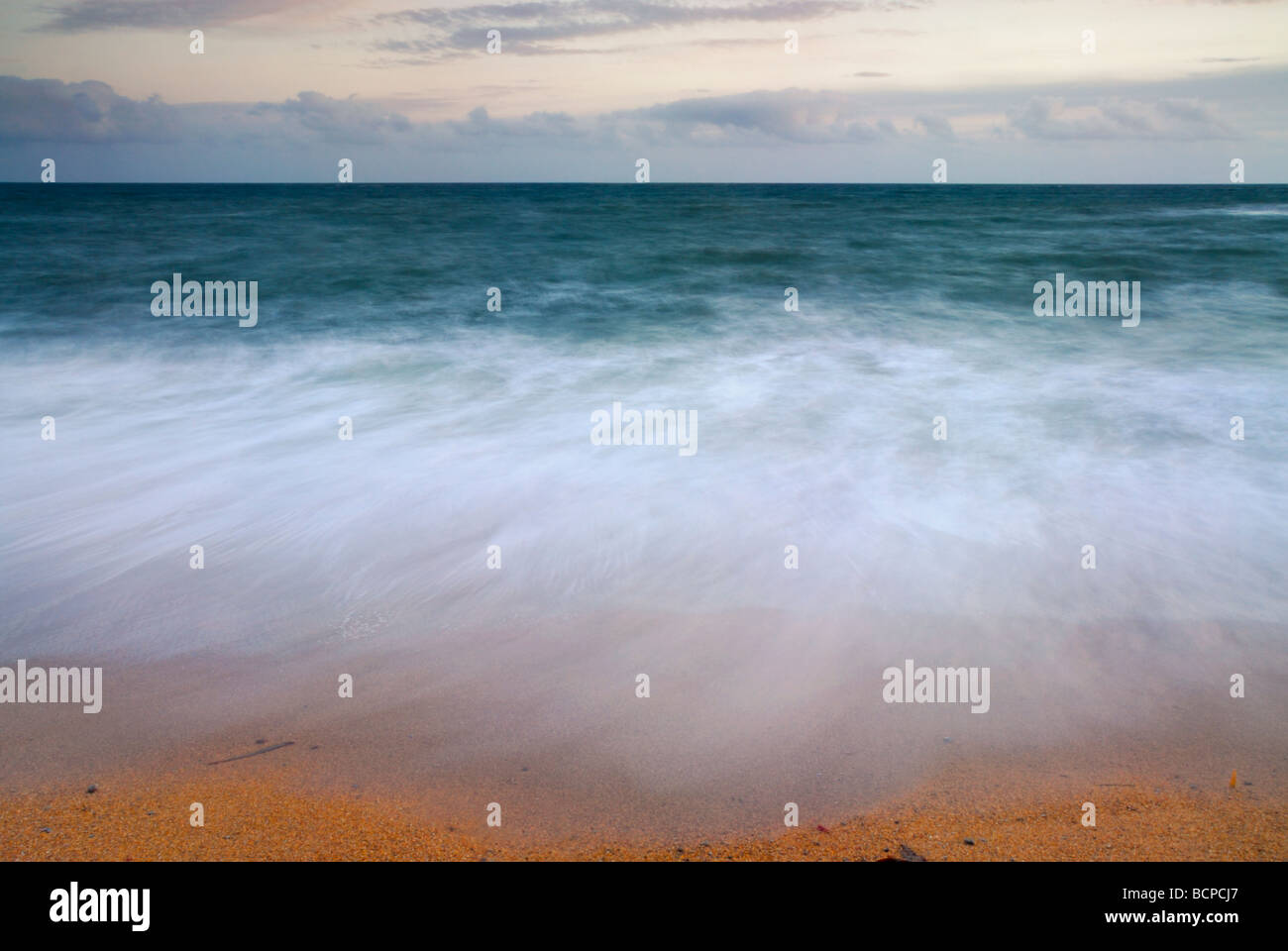 Motion blur image of surf washing up against the shoreline Dorset coast england UK Stock Photo