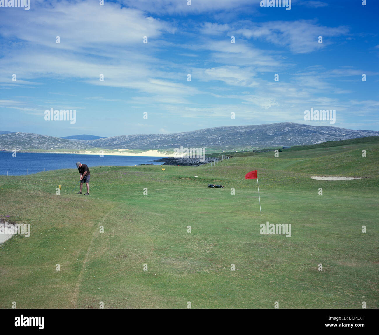 A holiday golfer on one of Scotland's most remote golf courses at Isle of Harris Golf club at Scarista. Stock Photo