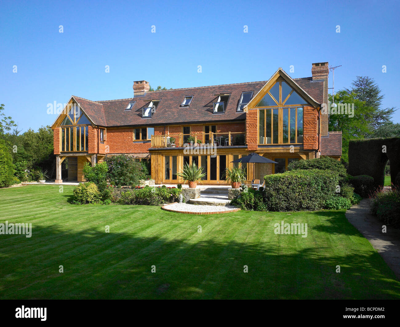Exterior of a large refurbished house with 'bifold' doors, velux windows and lots of glass. Stock Photo