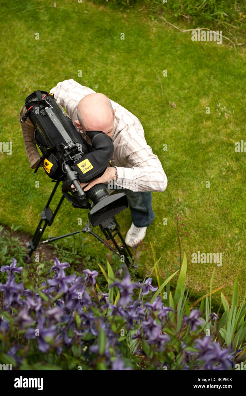 A freelance self employed Cameraman filming the plants and flowers at Powis Castle welshpool Powys WALES UK Stock Photo