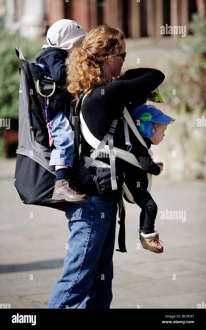 A mother with two children strapped to her in Coventry, UK Stock Photo